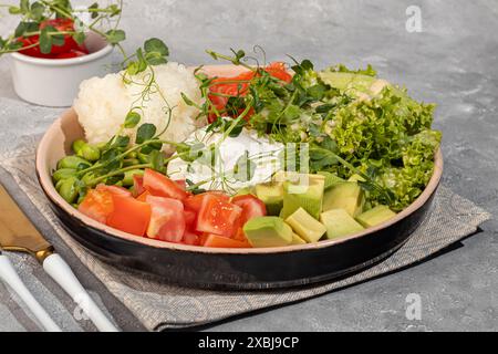 Salatschüssel mit Reis, Lachs, Tomaten, Gurken und Avocado. Pochiertes Ei. Kopierbereich Stockfoto