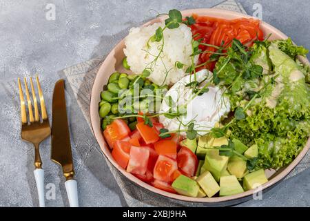 Salatschüssel mit Reis, Lachs, Tomaten, Gurken und Avocado. Pochiertes Ei. Kopierbereich Stockfoto