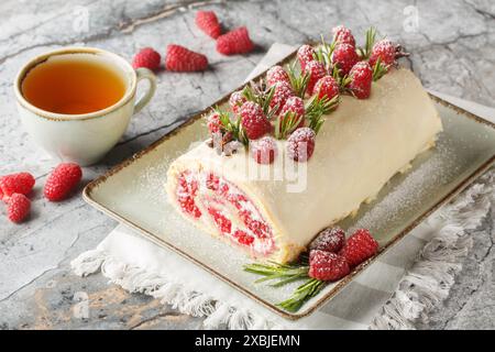 Weihnachtsgebäck mit Sahne, Marmelade und frischen Himbeeren in Nahaufnahme auf dem Teller auf dem Tisch. Horizontal Stockfoto