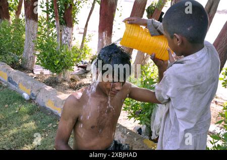 Ein Arbeiter, der am Mittwoch, den 12. Juni 2024, im Greenbelt in Hyderabad die Hitze der sengenden Sonne während des heißen Wetters der Sommersaison abwehrt. Stockfoto