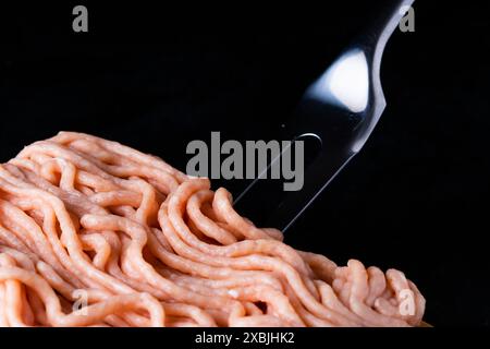 Hackfleisch auf Holz mit einer Gabel. Modisches Foto von Hackfleisch mit Platz für Text. Stockfoto