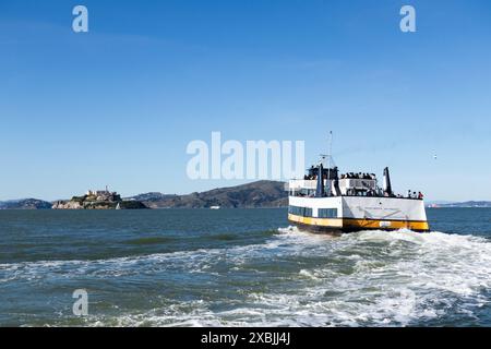 Die weiße und gelbe Fähre des Habour Kaisers bietet Passagiere mit Blick über die Bucht von San Francisco nach Alcatraz Island San Francisco Kalifornien USA Stockfoto