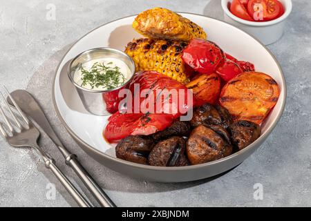 Gegrilltes Gemüse auf einem Teller, Mais und Paprika, Pilze und Sauce. Kopierbereich Stockfoto