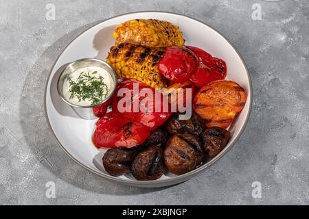 Gegrilltes Gemüse auf einem Teller, Mais und Paprika, Pilze und Sauce. Kopierbereich Stockfoto