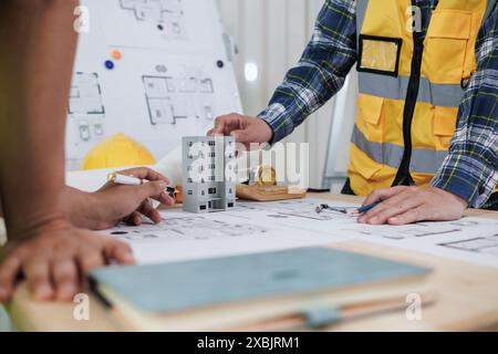 Das Ingenieurwesen diskutiert derzeit mit Architekten Fragen der Tragwerksplanung, um Pläne zu überprüfen, die auf die Konstruktion und die Stabilität des Gebäudes abgestimmt sind. Konzept j Stockfoto