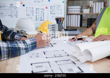 Das Ingenieurwesen diskutiert derzeit mit Architekten Fragen der Tragwerksplanung, um Pläne zu überprüfen, die auf die Konstruktion und die Stabilität des Gebäudes abgestimmt sind. Konzept j Stockfoto