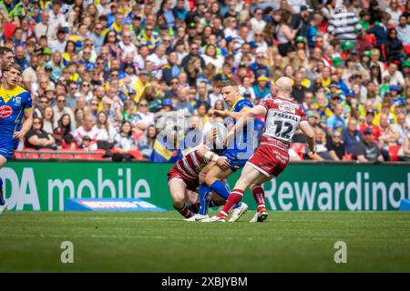 Das Finale Des Betfred Challenge Cups 2024. George Williams wird von Liam Farrell und Harry Smith angegriffen Stockfoto