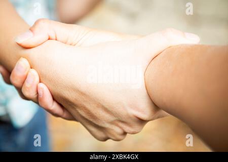 Zwei Hände verriegelt. Teamarbeit und Konzept zur Festlegung von Vereinbarungen. Solidarität und Unterstützung von Frauen. Kaukasische Palme. Stärke und Zusammenarbeit. Finger mit Stockfoto