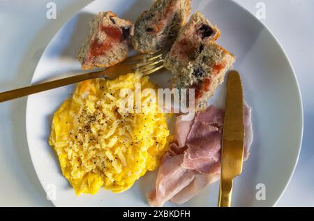 Rührei mit Schinken und Heidelbeermuffin Stockfoto