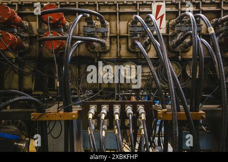 Teil der Industriemaschine. Angeschlossene Hochspannungskabel, Voltmeter und Rohre. Stockfoto