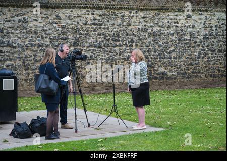 Reife Dame, die vor dem Mikrofon steht und ein Kameramann ein Video macht. Möglicherweise ein Interview. Westminster London Großbritannien Stockfoto
