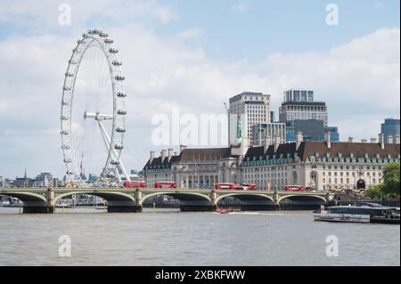 Rote Busse auf der Westminster Bridge London Eye Riesenrad South Bank Uber Boot nähert sich der Brücke London England Großbritannien Stockfoto