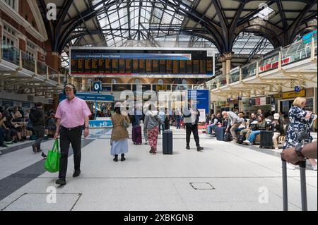 Haupthalle Liverpool Street Bahnhof mit vielen Leuten. Elektronische Informationstafel für Ankunft und Abflug im Hintergrund. London England Stockfoto