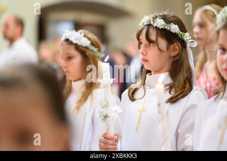 Kinder in Bänken bei ihrer ersten Kommunionmesse. Stockfoto