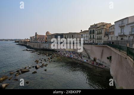 Syrakus, Sizilien, Italien - 24. August 2023: Ein kleiner Strand an der „Spiaggia di Cala Rossa“ auf der Ostseite von Ortigia in Syrakus, Sizilien, Italien Stockfoto