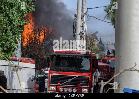 Athen, Griechenland. 12. Juni 2024. Flammen und schwarzer Rauch steigen in den Himmel, während Feuerwehrleute in einer Kochgeschirrfabrik im nördlichen Athener Vorort Kifissia mit einem Feuer kämpfen, das durch mehrere Explosionen verursacht wurde. Die Behörden warnten die Bewohner, wegen einer möglichen toxischen Wolke drinnen zu bleiben. Quelle: Dimitris Aspiotis/Alamy Live News Stockfoto