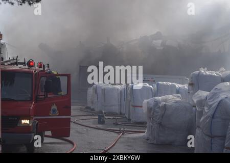 Athen, Griechenland. 12. Juni 2024. Eine Wolke aus schwarzem Rauch ist zu sehen, während Feuerwehrleute mit einem Feuer kämpfen, das durch mehrere Explosionen in einer Kochgeschirrfabrik im nördlichen Athener Vorort Kifissia verursacht wurde. Die Behörden warnten die Bewohner, wegen einer möglichen toxischen Wolke drinnen zu bleiben. Quelle: Dimitris Aspiotis/Alamy Live News Stockfoto