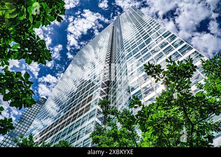 200 West Street, flacher Blick, Außenansicht des Gebäudes umgeben von Bäumen vor Wolken und blauem Himmel, New York City, New York, USA Stockfoto