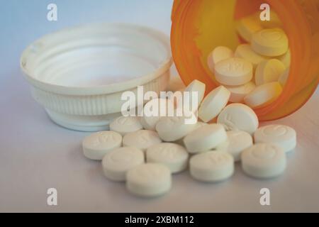 Generisches Metformin, abgegeben aus einer Apotheke 500 mg Tabletten auf weißem Hintergrund. In die orangene verschreibungspflichtige Flasche schauen. Stockfoto