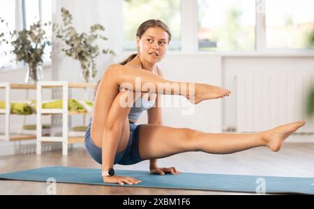 Mädchen mit fortgeschrittenem Arm Balancing Asana Eka Hasta Bhujasana Stockfoto