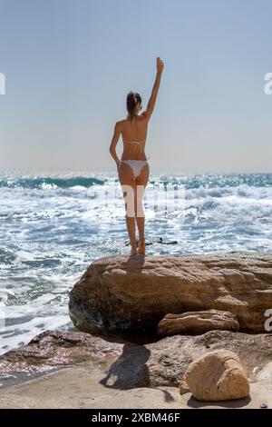 Brünette Frau in Bikini mit Blick auf das Meer am Strand Cabo de Gata Andalusien, Spanien Stockfoto