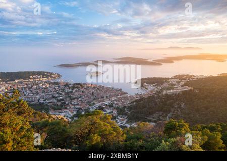 Blick auf die Altstadt von Hvar bei Sonnenuntergang, hinter Pakleni- oder Paklinski-Inseln, Dalmatien, Kroatien Stockfoto