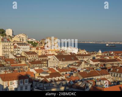 Stadtlandschaft mit roten Dächern und Meerblick an klaren Tagen, Lissabon, portugal Stockfoto