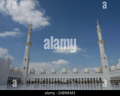 Große Moschee mit Minaretten und weißer Architektur unter klarem Himmel, abu dhabi, vereinigte arabische emirate Stockfoto