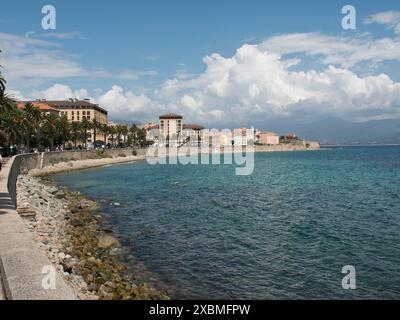 Stadt an der Küste mit Promenade und Gebäuden vor einem blauen Himmel mit Wolken, ajaccio, korsika, frankreich Stockfoto