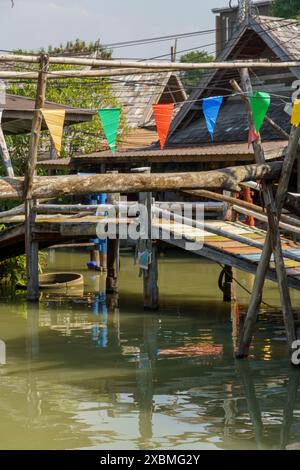 Holzbrücke mit bunten Wimpeln über einen Kanal auf dem schwimmenden Markt, Pattaya, Thailand Stockfoto