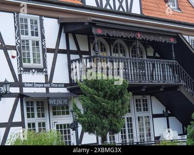 Traditionelles Fachwerkhaus mit weißer Fassade, dunklem Holzbalkon und roten Fliesen auf dem Dach, Danzig, Polen Stockfoto