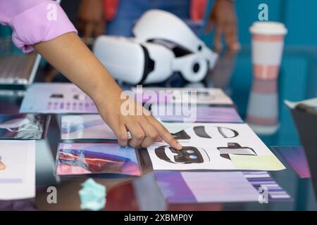 Birassische junge Frau und ein afroamerikanischer Mann diskutieren über das Design von VR-Headsets und die Teamarbeit im Unternehmen Stockfoto
