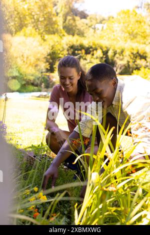 Glückliches, vielseitiges Paar, das zusammen im Garten arbeitet Stockfoto