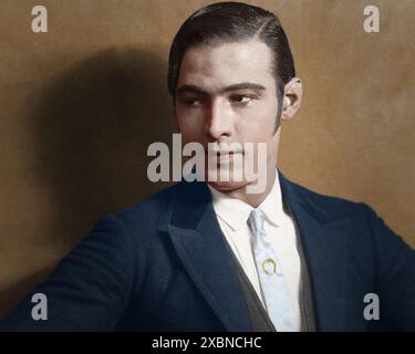 Ein Vintage-Foto mit einem Mann in einem zeitlosen Anzug mit geschliffenem Haar, das klassische Eleganz und einen raffinierten Stil zeigt, der typisch für die Mode des frühen 20. Jahrhunderts ist. Dies ist ein Studio-Porträt von Rudolph Valentino, geboren als Rodolfo Pietro Filiberto Raffaello Guglielmi di Valentina d’Antonguella am 6. Mai 1895 in Castellaneta, Italien. Er war eine ikonische Figur der Stummfilmzeit. Bekannt als der „große Liebhaber“, starb er am 23. August 1926. Sein frühzeitiger Tod an Peritonitis im Alter von 31 Jahren verursachte Massenhysterie unter seinen Fans und festigte seinen Platz in der Filmgeschichte. Er war auch bekannt als der „lateinische Liebhaber“ Stockfoto