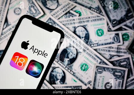 Krakau, Polen. Juni 2024. In dieser Fotoabbildung ist ein Apple iOS 18-Logo auf einem Apple iPhone mit US-Dollar-Banknoten im Hintergrund zu sehen. Nach der Präsentation des neuen iOS auf dem WWDC kam es zu Kontroversen und Bedenken bezüglich Datenschutzproblemen im Zusammenhang mit den KI-basierten Funktionen. Quelle: SOPA Images Limited/Alamy Live News Stockfoto