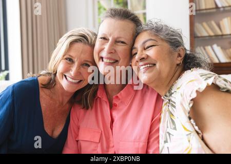 Verschiedene Gruppe reifer Frauen, die im Wohnzimmer zu Hause lächeln Stockfoto