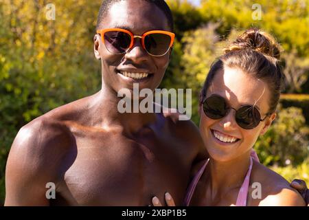 Junge, vielfältige Paare, die zusammen am Pool lächeln, Sommer, Sonnenschein, Glück, Liebe Stockfoto