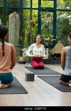 Eine vielfältige Gruppe von Frauen, die Yoga mit birassischer Lehrerin üben, Kopierraum Stockfoto