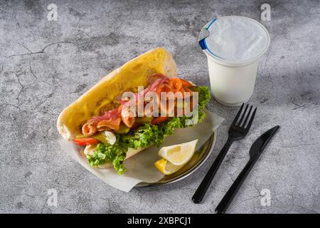 Sandwich mit geräuchertem Lachs auf Metallteller auf Steintisch Stockfoto