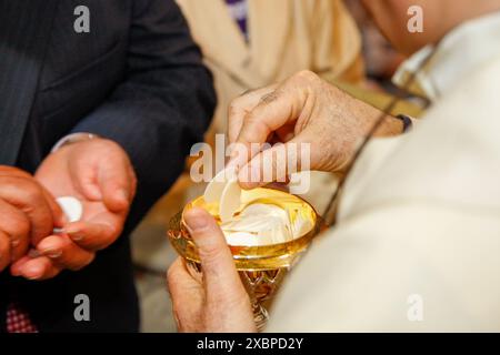 Priester mit goldenem Kelch und geweihten Gastgebern während der eucharistischen Feier einer heiligen Messe Stockfoto