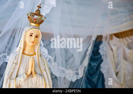 Statue unserer Dame von fatima mit einer Krone, in einem weißen Kleid, und ihre Hände unter einem weißen Schleier zusammengehalten Stockfoto