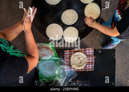Mexikanische Frauen kochen Tortillas auf dem comal in einem tortillería in Morelia, Michoacán, Mexiko. Stockfoto