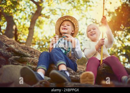 Freunde, Junge und Mädchen mit Lächeln, Wald und Kinder auf dem Land, draußen und glücklich im Urlaub. Bindungen, Geschwister und Kinder im Sommer, lachen Stockfoto