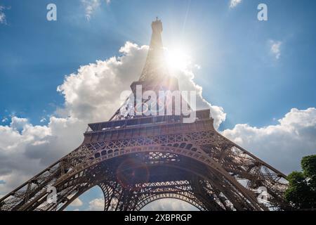 Weitwinkelblick auf den Eiffelturm mit Ringen für die Olympischen Spiele 2024 und Sonnenstrahlen Stockfoto