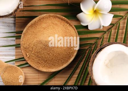 Kokosnusszucker, Palmblätter, Früchte und Bambusmatte auf dem Tisch, flache Ladefläche Stockfoto