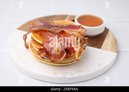 Leckere Pfannkuchen mit Speck und Honig auf weißem Tisch, Nahaufnahme Stockfoto