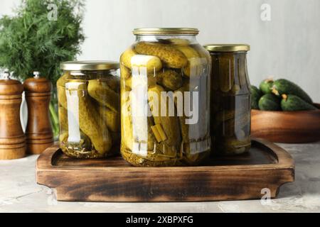 Eingelegte Gurken in Gläsern auf grauem Tisch Stockfoto