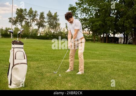Ein Mann in eleganter Kleidung schwingt einen Golfclub auf einem grünen Feld, Freizeit der gehobenen Klasse. Stockfoto