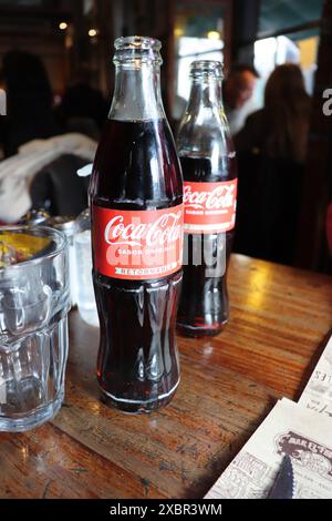 Zwei Flaschen Coca Cola auf einem Tisch in einer traditionellen Bar in Buenos Aires Stockfoto