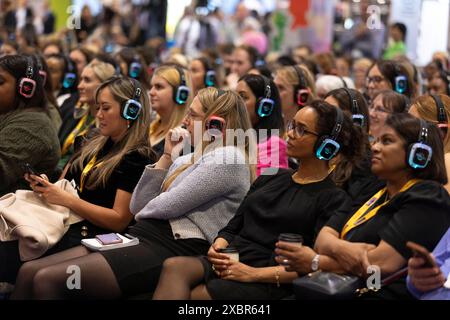 Die Teilnehmer auf der Messe hören den Hauptredner auf den Kopfhörern Stockfoto